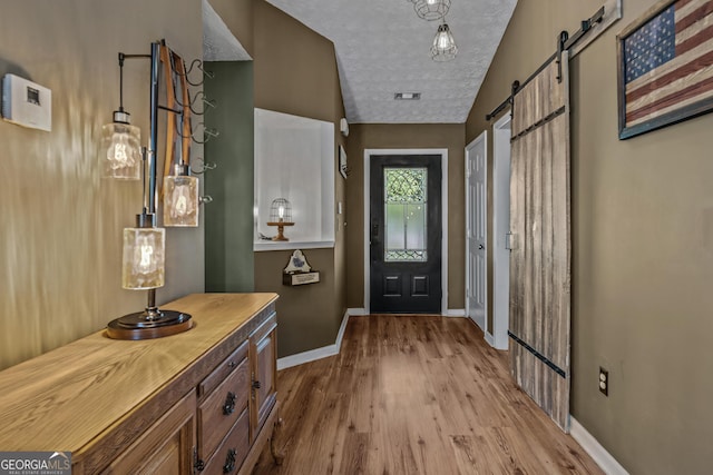 108 Wortham Dr, Buckhead, GA 30625 - entryway with a barn door, wood finished floors, baseboards, and a textured ceiling