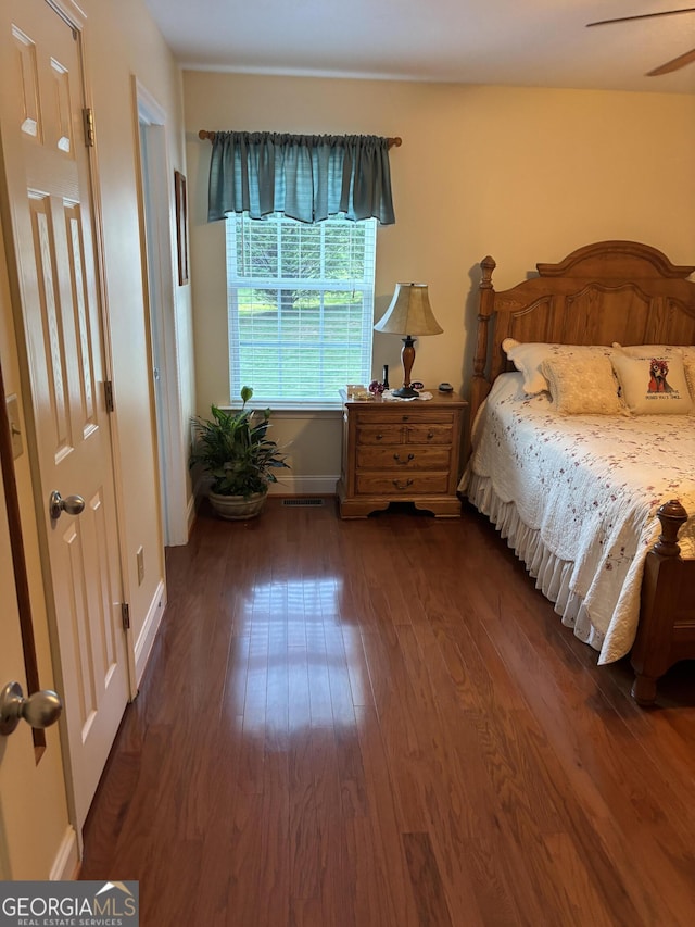 bedroom with dark wood finished floors and baseboards