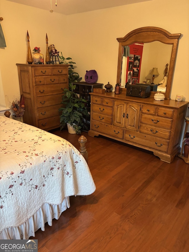 bedroom with dark wood-style flooring