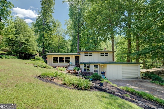 3449 Archwood Dr, Doraville, GA 30340 - split level home featuring asphalt driveway, a garage, a front yard, a chimney, and board and batten siding