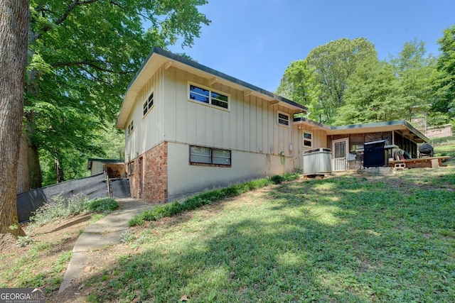 3449 Archwood Dr, Doraville, GA 30340 - rear view of house featuring board and batten siding, a yard, and brick siding