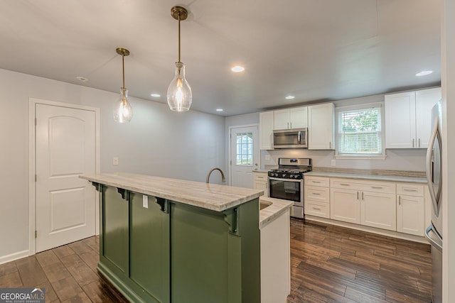 947 Rebel Forest Dr, Atlanta, GA 30315 - kitchen featuring appliances with stainless steel finishes, a kitchen island with sink, white cabinetry, dark wood-style floors, and recessed lighting