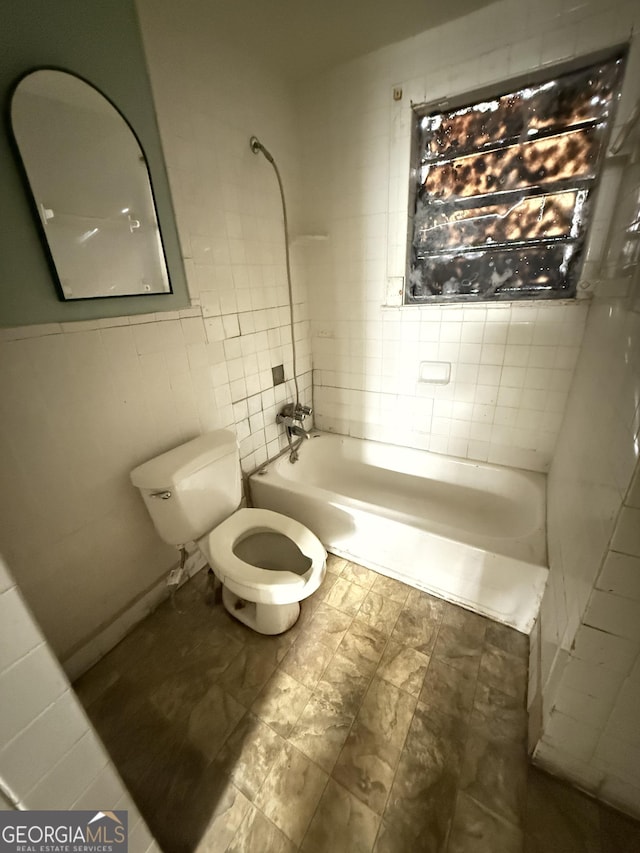 bathroom with tile walls, toilet, and bathing tub / shower combination