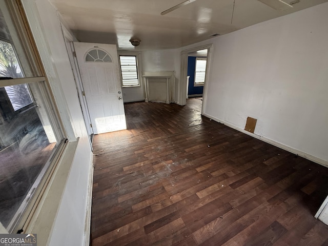 spare room featuring dark wood-style floors and baseboards