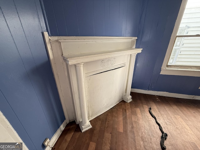 detailed view of wood finished floors, baseboards, and wooden walls