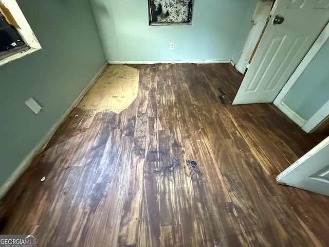 unfurnished bedroom featuring wood finished floors and baseboards
