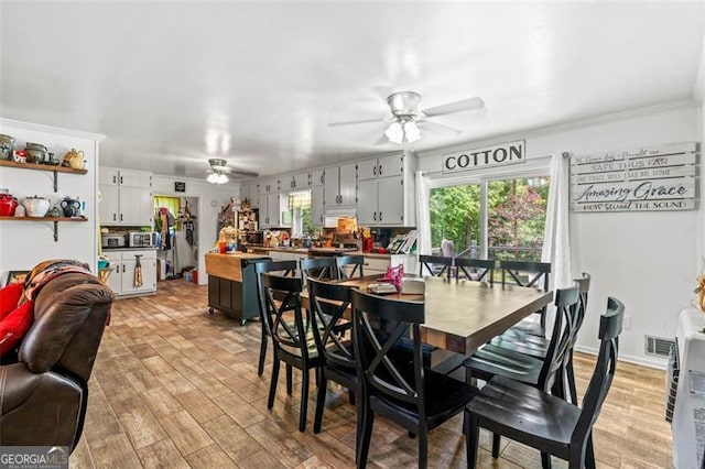 dining area with ceiling fan and light wood finished floors