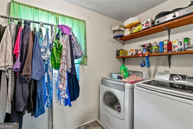 laundry area with independent washer and dryer and a textured ceiling