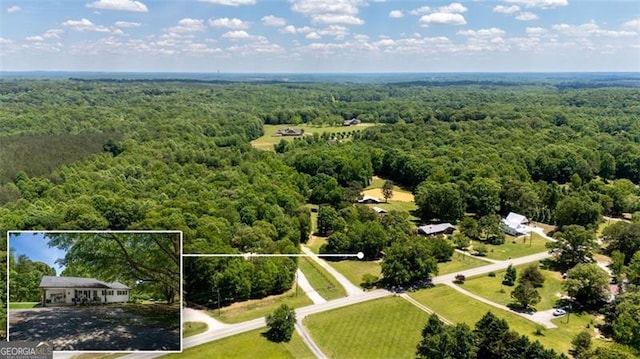 aerial view of property and surrounding area with a heavily wooded area and property boundaries highlighted
