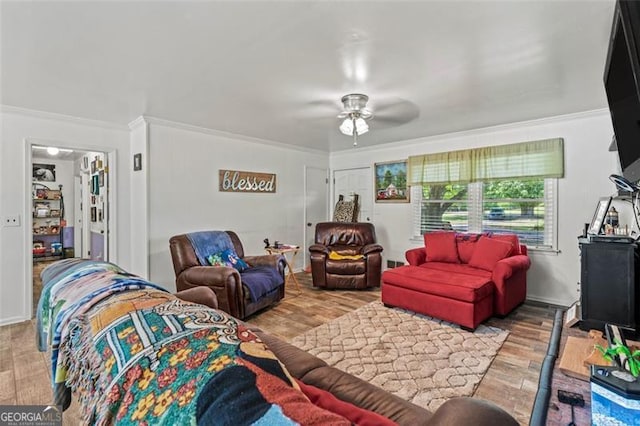 living room with wood finished floors, ceiling fan, and crown molding
