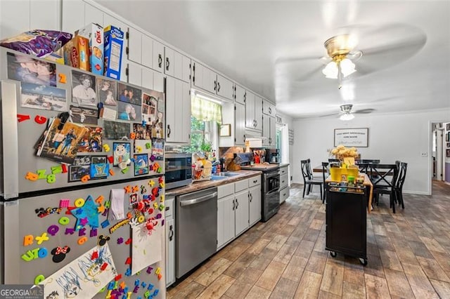 kitchen featuring appliances with stainless steel finishes, a ceiling fan, light wood-style flooring, white cabinetry, and light countertops