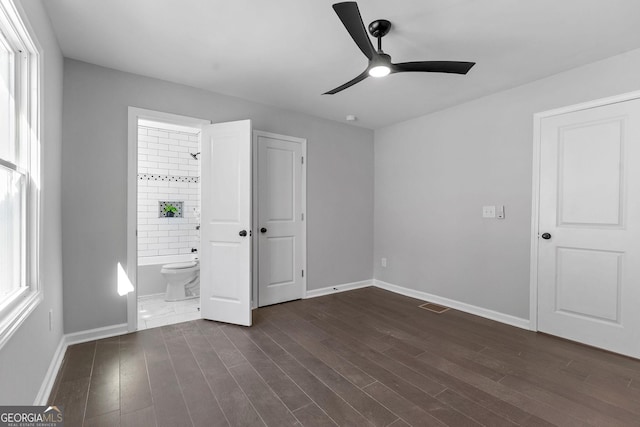 985 Columbia Dr, Decatur, GA 30030 - unfurnished bedroom featuring dark wood-style floors, baseboards, ensuite bath, and ceiling fan