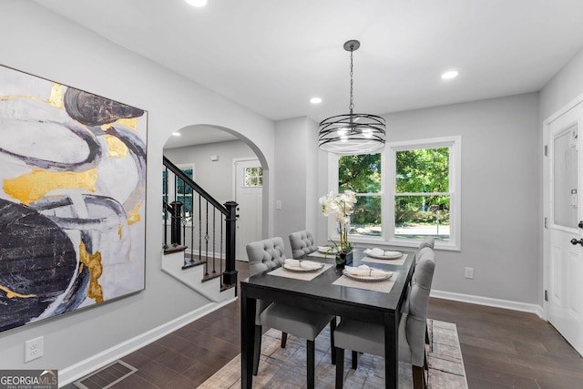 985 Columbia Dr, Decatur, GA 30030 - dining room featuring dark wood-style flooring, arched walkways, recessed lighting, stairway, and baseboards