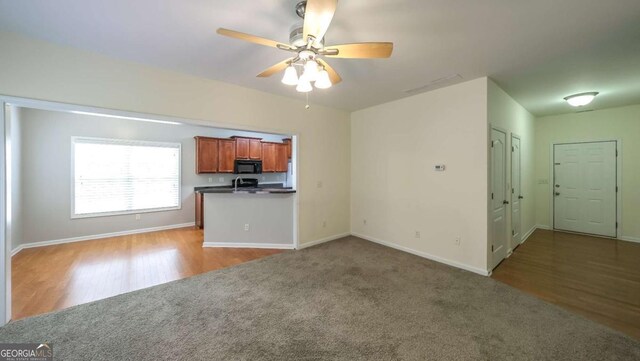 416 Clarion Dr, Carrollton, GA 30116 - unfurnished living room featuring baseboards, a ceiling fan, carpet flooring, and wood finished floors