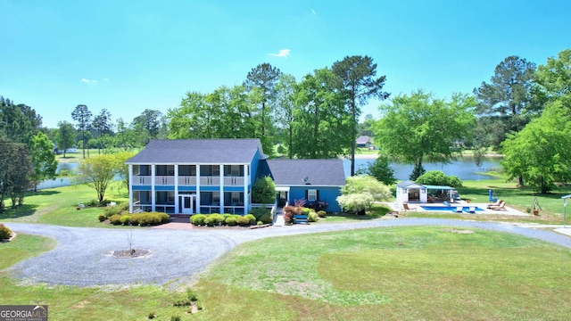 114 N Valhalla Dr, Cordele, GA 31015 - view of front facade featuring a sunroom, a water view, a front lawn, an outdoor pool, and view of wooded area