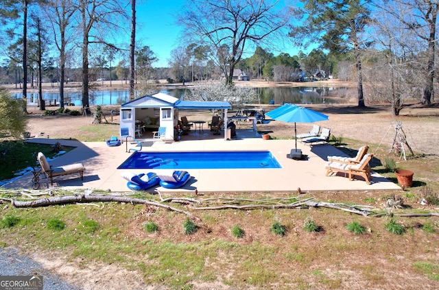 114 N Valhalla Dr, Cordele, GA 31015 - outdoor pool featuring a patio area, a water view, an outbuilding, and view of scattered trees