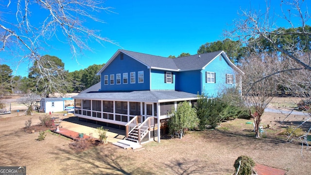114 N Valhalla Dr, Cordele, GA 31015 - back of house with a sunroom, roof with shingles, an outdoor structure, and a storage shed