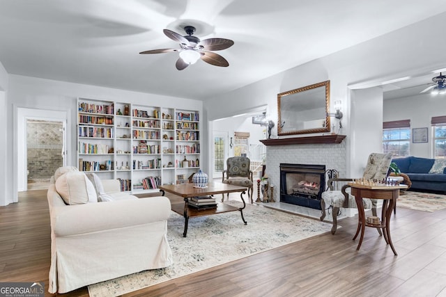 114 N Valhalla Dr, Cordele, GA 31015 - living room with a ceiling fan, a brick fireplace, wood finished floors, and built in shelves