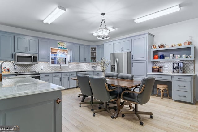 114 N Valhalla Dr, Cordele, GA 31015 - kitchen featuring open shelves, stainless steel appliances, backsplash, a desk, and pendant lighting