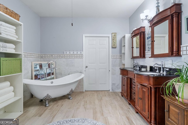 114 N Valhalla Dr, Cordele, GA 31015 - full bath with tile walls, wood finished floors, a wainscoted wall, double vanity, and a soaking tub