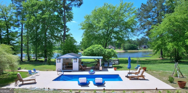 114 N Valhalla Dr, Cordele, GA 31015 - outdoor pool featuring a storage structure, a lawn, a water view, a patio, and an outbuilding