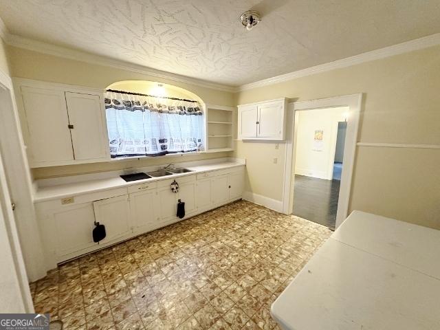 210 W Church St, Swainsboro, GA 30401 - kitchen with white cabinets, light countertops, crown molding, light flooring, and open shelves