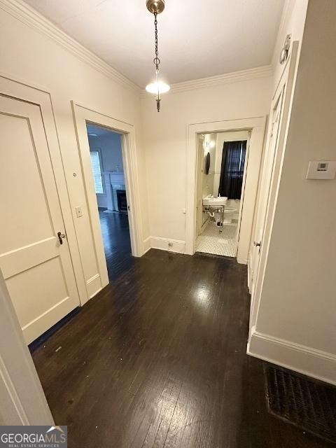210 W Church St, Swainsboro, GA 30401 - unfurnished dining area featuring dark wood-type flooring, ornamental molding, and baseboards