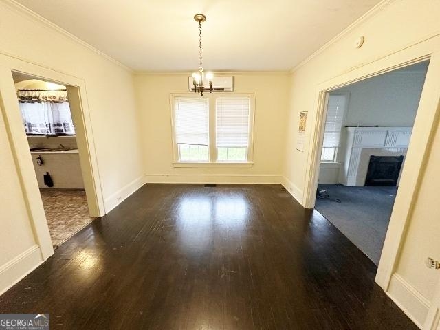 210 W Church St, Swainsboro, GA 30401 - unfurnished dining area with a chandelier, ornamental molding, dark wood-style flooring, plenty of natural light, and a fireplace