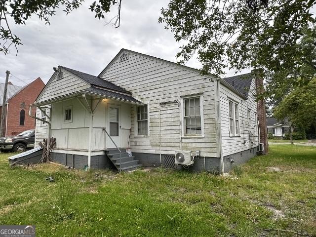 210 W Church St, Swainsboro, GA 30401 - view of front of property featuring crawl space, a cooling unit, and a front lawn