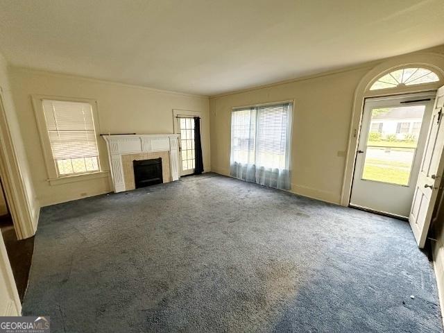 210 W Church St, Swainsboro, GA 30401 - unfurnished living room with carpet and a fireplace