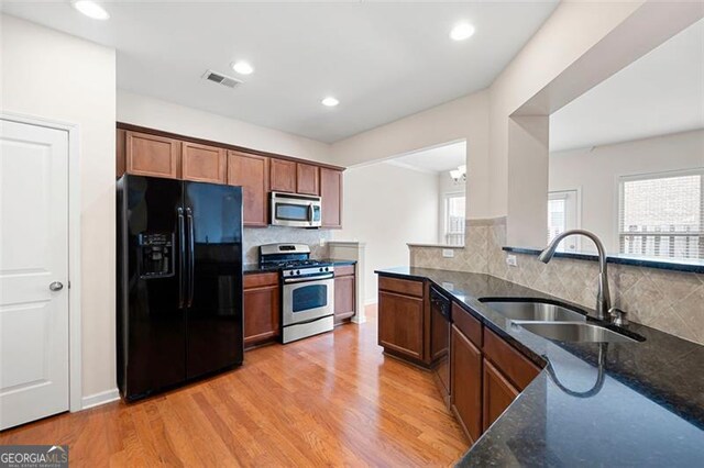 1957 Brightleaf Way Unit 59, Marietta, GA 30060 - kitchen with appliances with stainless steel finishes, a sink, dark stone counters, backsplash, and light wood-style flooring