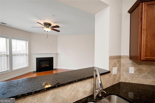 1957 Brightleaf Way Unit 59, Marietta, GA 30060 - kitchen featuring a ceiling fan, a sink, dark stone countertops, and brown cabinets