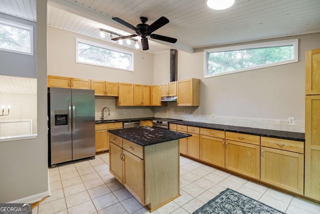 kitchen featuring appliances with stainless steel finishes, a sink, light tile patterned floors, light brown cabinets, and a towering ceiling