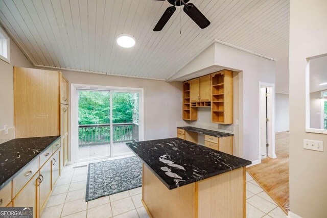 kitchen with light tile patterned floors, open shelves, a ceiling fan, dark stone counters, and light brown cabinetry