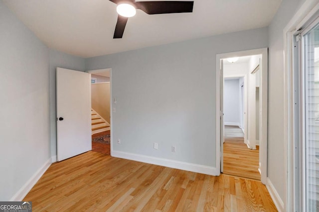 unfurnished bedroom with light wood-type flooring, baseboards, and ceiling fan
