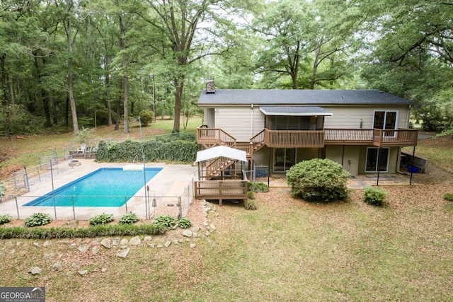view of pool featuring a deck, stairway, a patio, and view of scattered trees