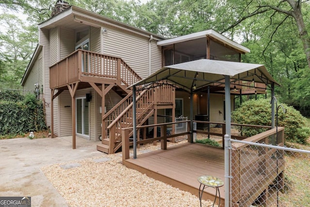 back of property with a deck, stairway, and a patio