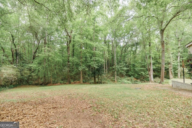 view of yard featuring a forest view
