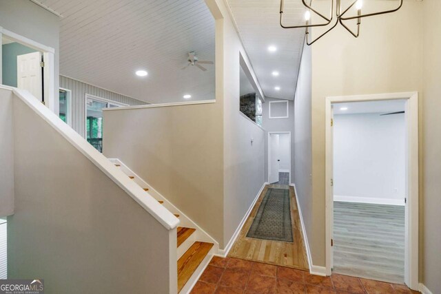 stairway featuring tile patterned flooring, recessed lighting, a chandelier, a ceiling fan, and baseboards