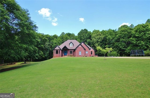 454 Primrose Ln, Pendergrass, GA 30567 - view of front of home featuring a front lawn, a trampoline, and a wooded view