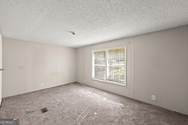 carpeted empty room with a textured ceiling