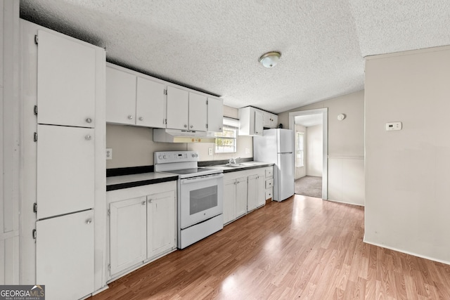 kitchen with white appliances, a textured ceiling, dark countertops, light wood-type flooring, and white cabinetry