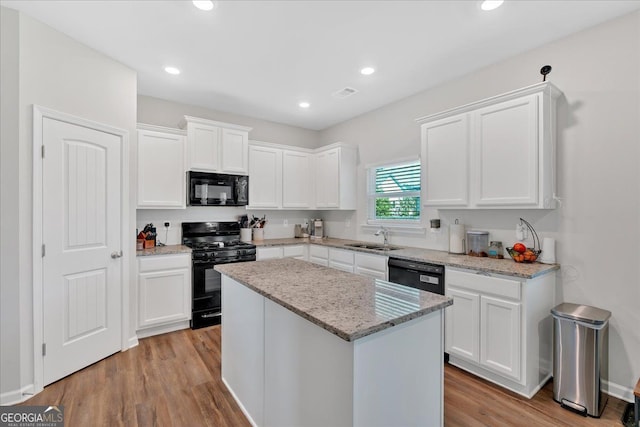 48 Sweetgum Trce, Dallas, GA 30132 - kitchen with black appliances, a sink, white cabinets, light wood finished floors, and a center island