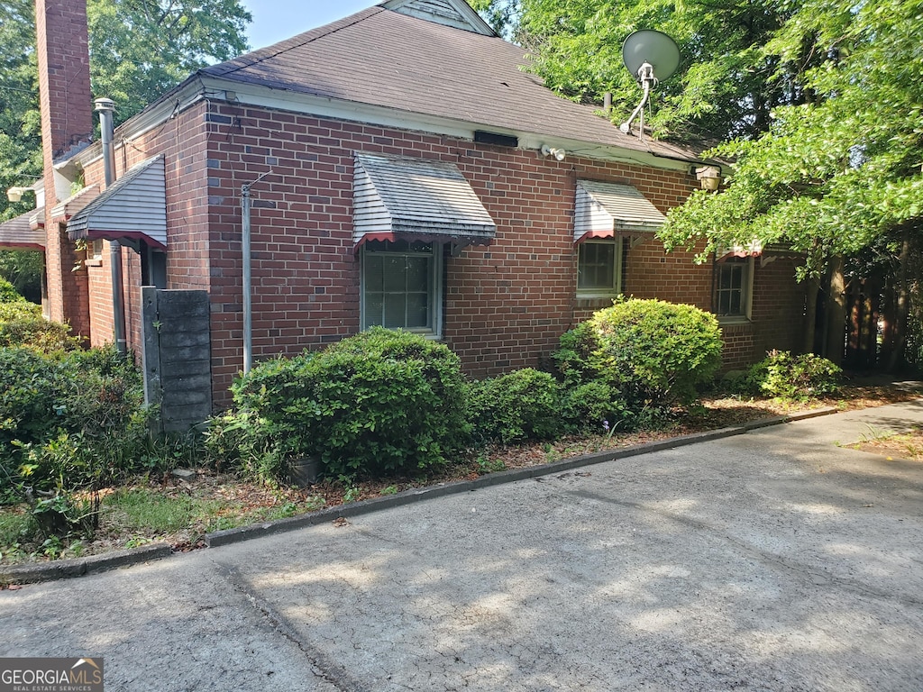 view of home's exterior with brick siding and a chimney