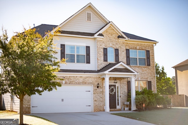 craftsman house with concrete driveway, brick siding, an attached garage, and fence