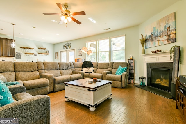 living room featuring a ceiling fan, wood-type flooring, plenty of natural light, a glass covered fireplace, and recessed lighting