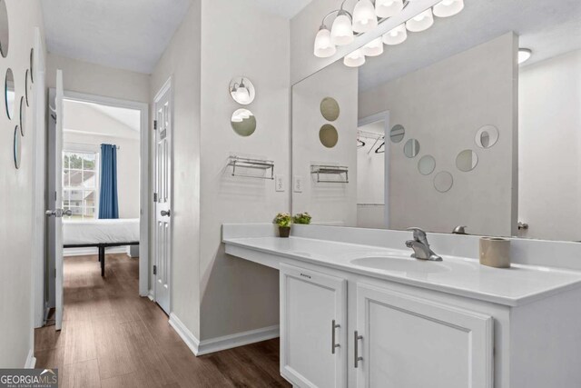 26 Springbottom Dr, Lawrenceville, GA 30046 - bathroom with wood finished floors, vanity, baseboards, and ensuite bath