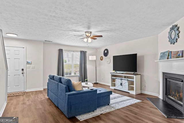 26 Springbottom Dr, Lawrenceville, GA 30046 - living room with a ceiling fan, wood finished floors, a glass covered fireplace, a textured ceiling, and baseboards