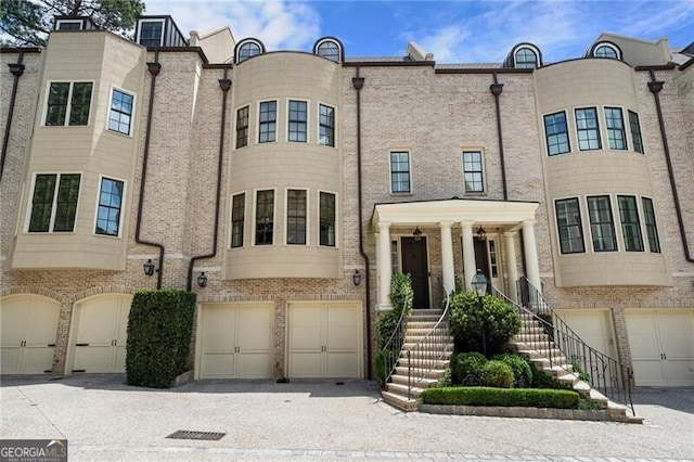 122 Old Ivy Rd NE Unit 17, Atlanta, GA 30342 - view of front facade with an attached garage and brick siding
