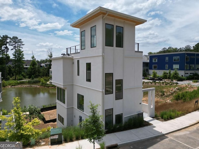 1230 Mado Loop, Chattahoochee Hills, GA 30268 - view of property exterior featuring stucco siding and a water view
